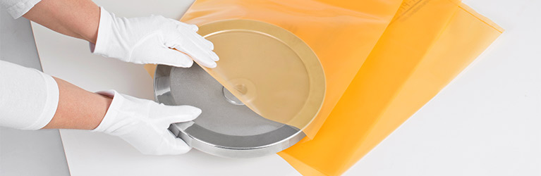 Person gibt Metallteil in VCI-Verpackung