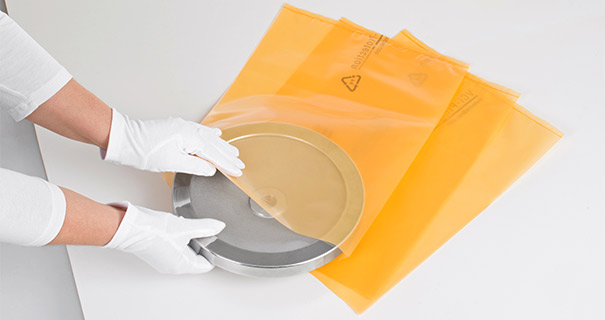 Person gibt Metallteil in VCI-Verpackung