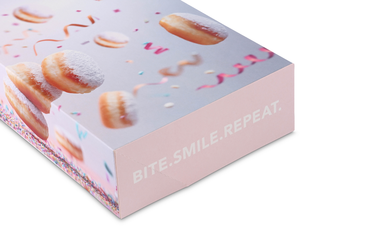 Boîte attrayante pour beignets ou pâtisseries avec l'inscription « bite.smile.repeat. ».