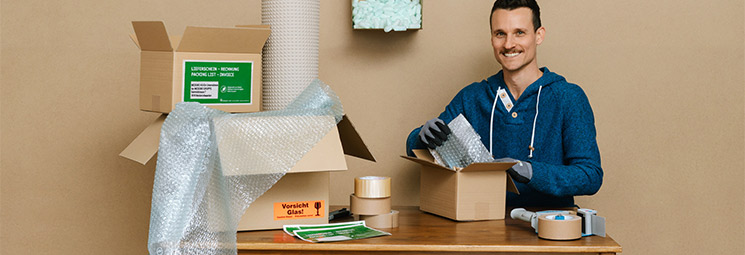 Mitarbeiter verpackt Ware für den Versand