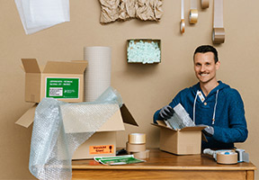 Mitarbeiter verpackt Ware für den Versand