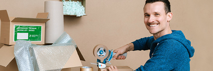 Mitarbeiter verpackt Ware für den Versand